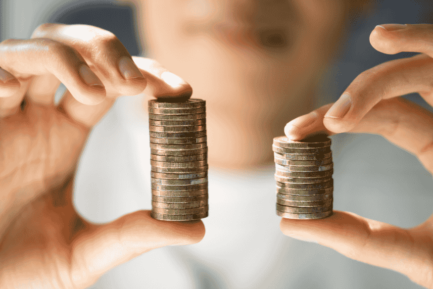 Pessoa comparando duas pilhas de moedas representando a diferença entre valor de mercado e valor de troca de um carro