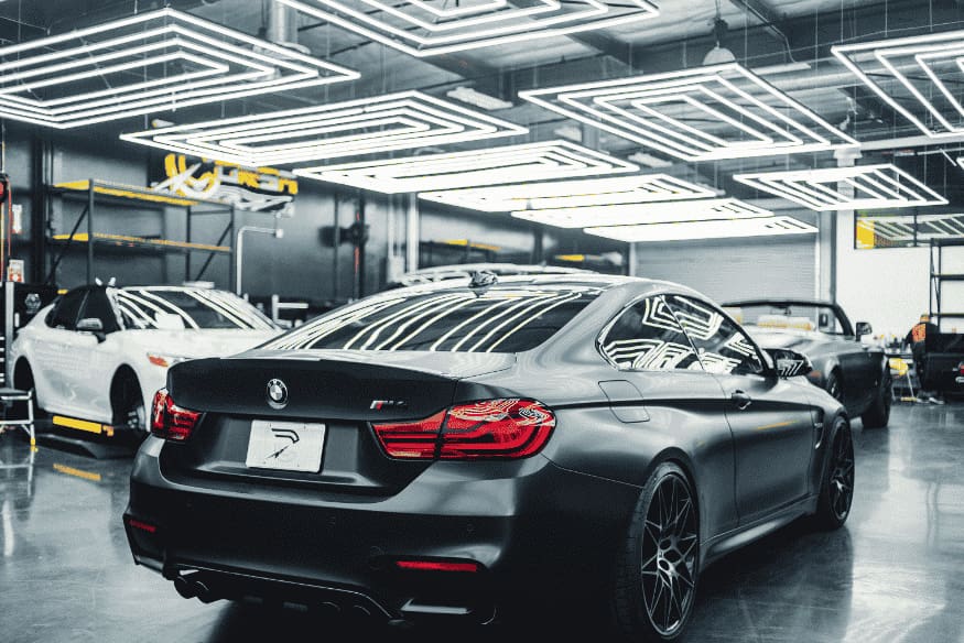 Carro elétrico em oficina moderna com manutenção simplificada, destacando a ausência de componentes mecânicos complexos como câmbio e escapamento.