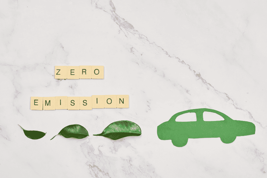 Símbolo de carro verde com folhas e palavras Zero Emission, representando políticas públicas e incentivos para carros elétricos no Brasil em 2025.