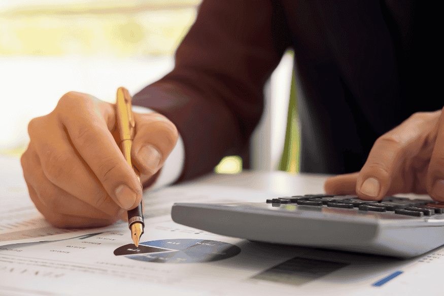 Pessoa calculando custo total de propriedade entre carro híbrido usado e modelo a gasolina, incluindo combustível, manutenção e impostos.