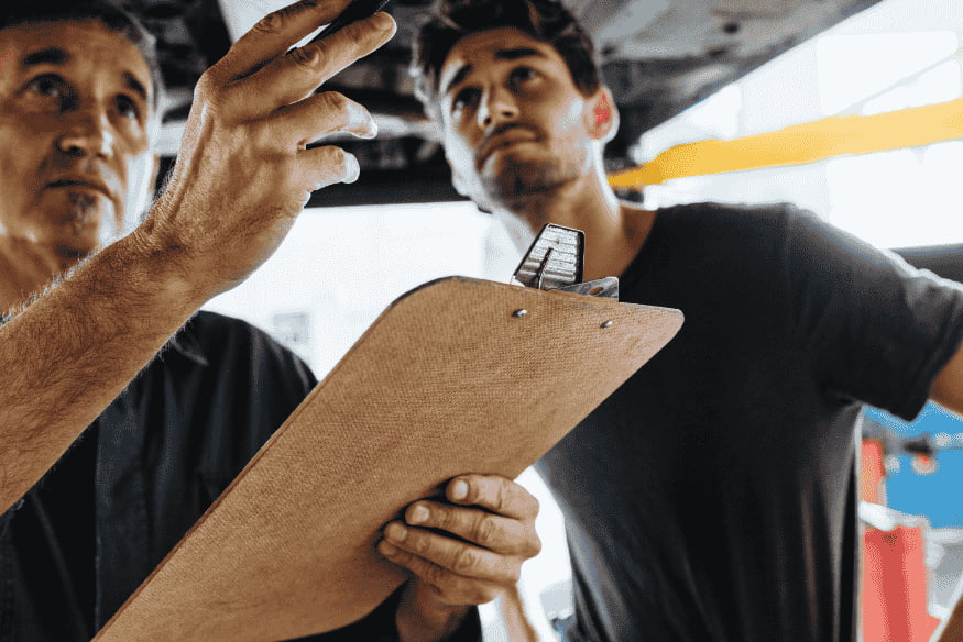 Mecânico realizando inspeção detalhada em veículo usado, parte essencial do checklist para comprar carro de particular com segurança.