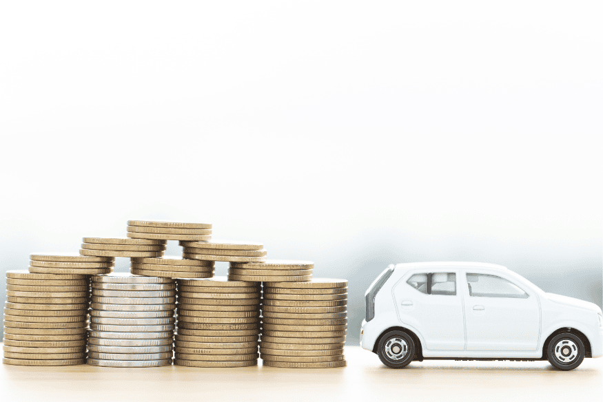 Miniatura de carro branco ao lado de pilhas de moedas representando os custos futuros de manutenção e uso de um carro usado