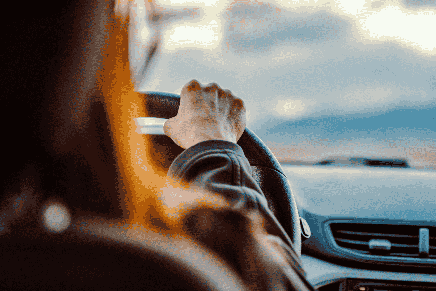 Motorista dirigindo carro ao entardecer, representando a escolha consciente e segura na compra de um carro usado em 2025