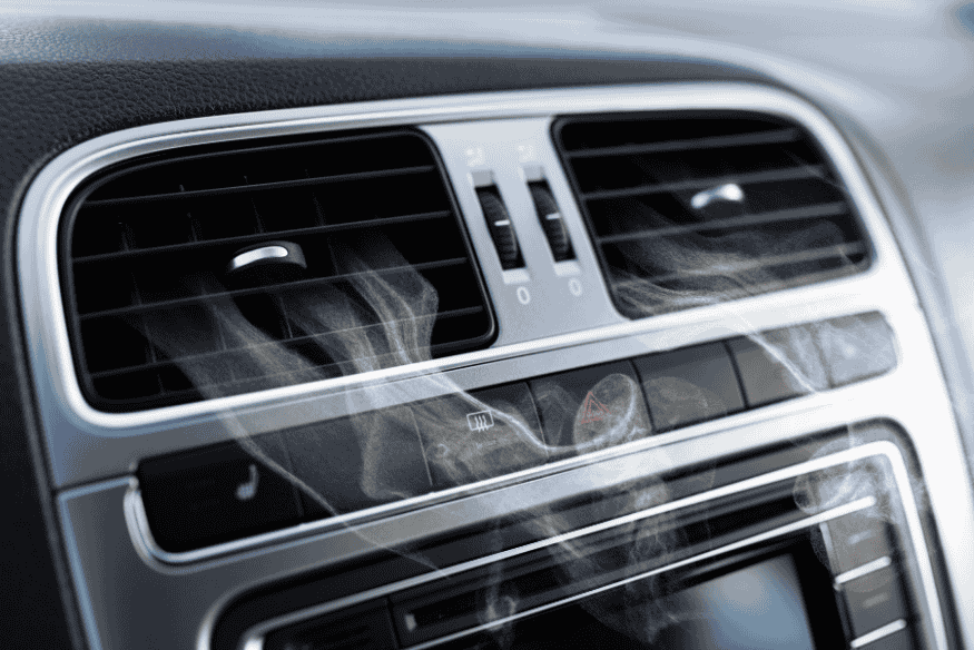 Saída de ar-condicionado de carro em funcionamento, ilustrando o impacto do uso excessivo no consumo de combustível.