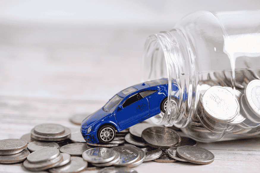 Miniatura de carro azul saindo de pote de moedas representando a depreciação e perda de valor de um carro popular no Brasil