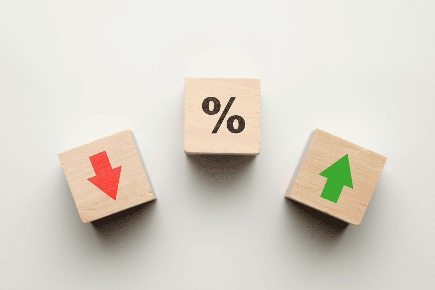 Blocos de madeira com símbolos de porcentagem, seta verde e seta vermelha, representando estratégias para economizar no seguro do carro sem perder cobertura.