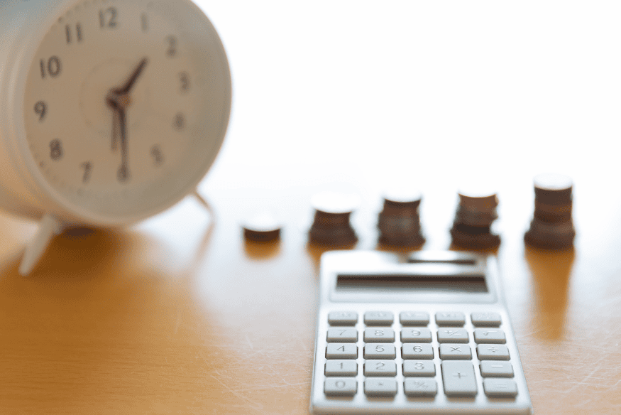 Relógio, moedas e calculadora representando a importância de não atrasar a renovação do seguro do carro para evitar custos mais altos.