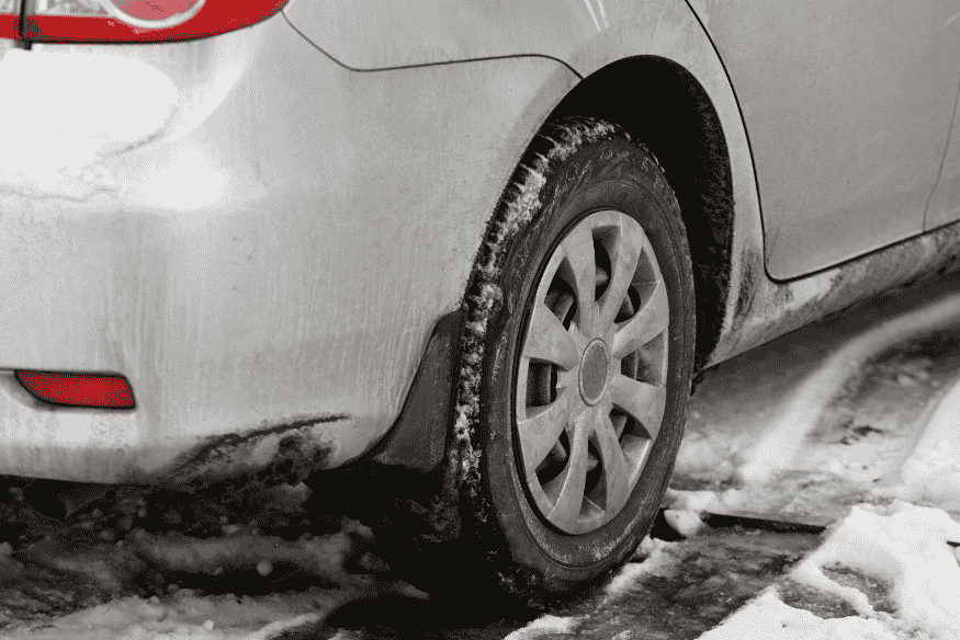 Carro parado em ambiente frio com neve, ilustrando a importância de aquecer o motor antes de dirigir em baixas temperaturas.