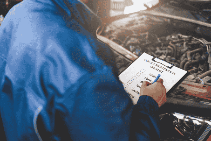Mecânico realizando checklist de manutenção preventiva em carro para garantir segurança e economia