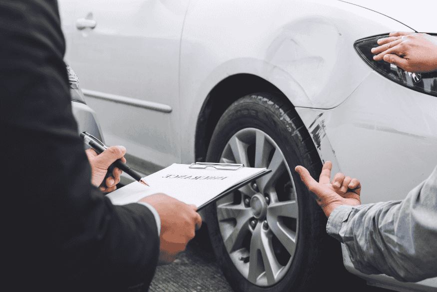 Avaliador de seguro analisando carro danificado, representando os fatores que determinam o valor do seguro para carros elétricos em 2025.