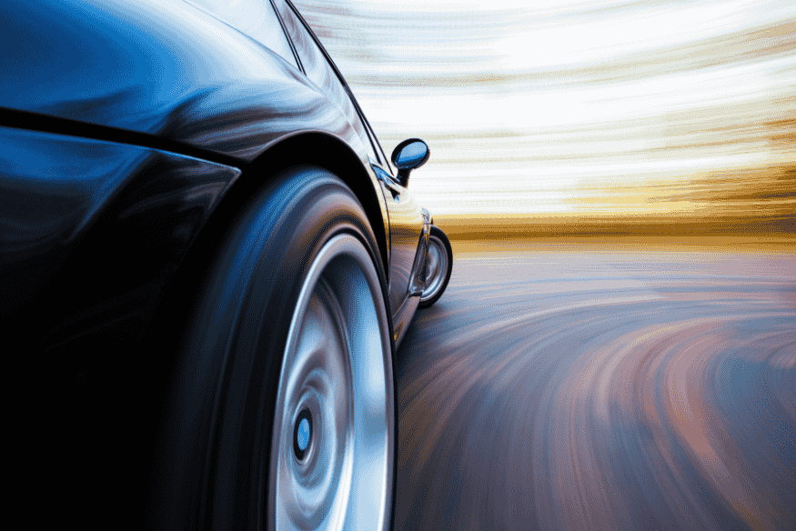 Carro em alta velocidade em curva representando desempenho e estabilidade de SUVs, hatches e sedãs