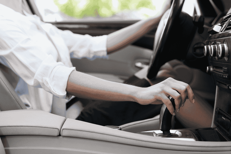 Motorista testando câmbio automático durante test-drive de carro usado ou novo