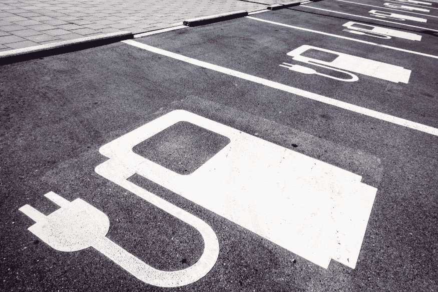 Vagas de estacionamento exclusivas para carros elétricos com símbolo de recarga, representando incentivos à infraestrutura no Brasil