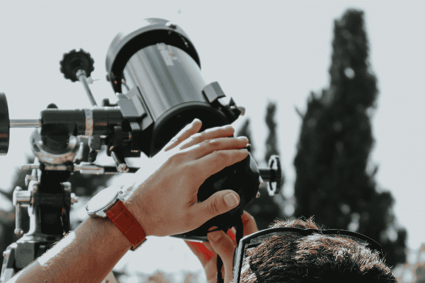 Pessoa ajustando o focador de um telescópio, etapa importante para obter foco correto antes de usar autoguiding