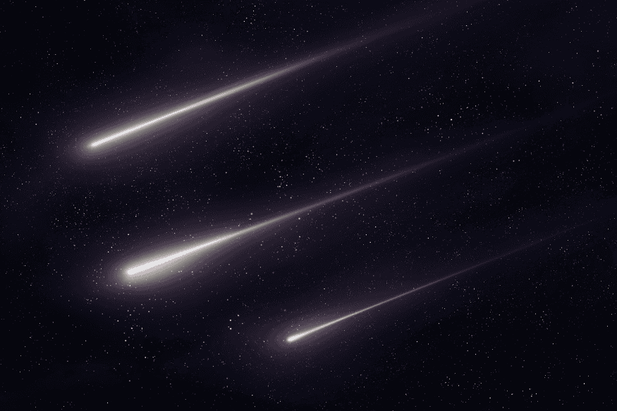 Vários meteoros brilhantes cruzando o céu escuro durante uma chuva de meteoros