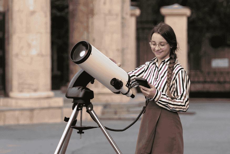 Pessoa usando telescópio com aplicativo no celular para configurar observação e verificar desempenho óptico do instrumento