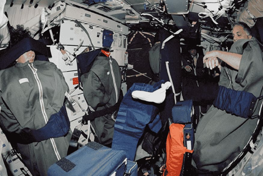 Astronautas em ambiente de microgravidade dentro de nave espacial, mostrando como o sono no espaço acontece sem cama tradicional