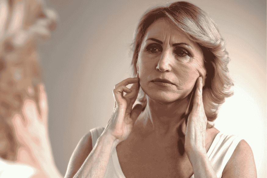 Mulher observando sinais de envelhecimento no rosto, relação entre mudanças corporais e vida em ambientes planetários diferentes