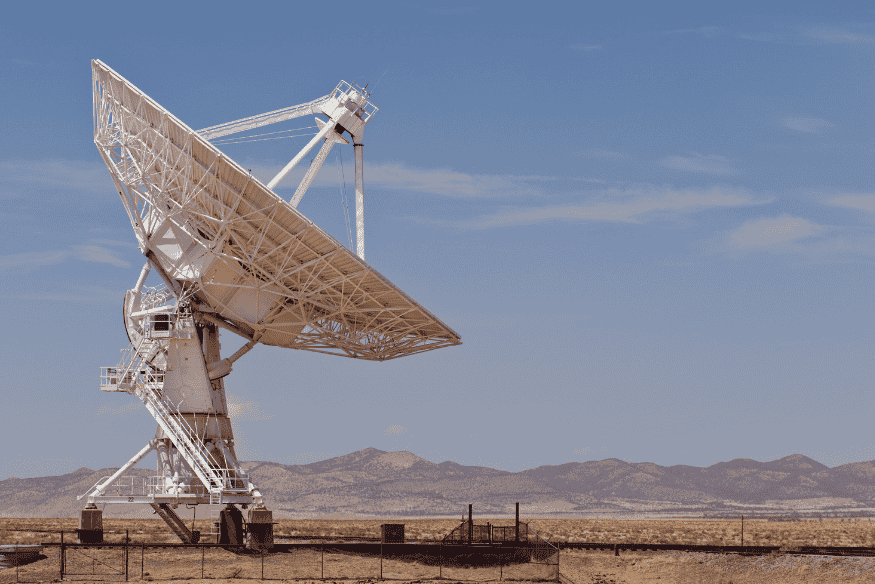 Grande radiotelescópio em área aberta, equipamento usado para investigar sinais de rádio vindos do Universo
