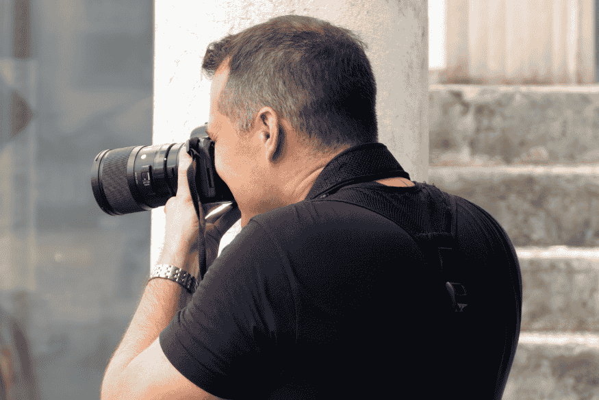 Fotógrafo usando câmera DSLR, simbolizando a repetição organizada de capturas para montar biblioteca de darks e bias