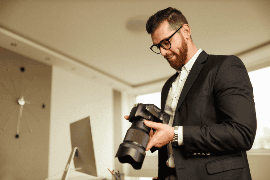 Fotógrafo segurando câmera com lente grande, representando a preparação do equipamento para capturas de calibração como flats, darks e bias
