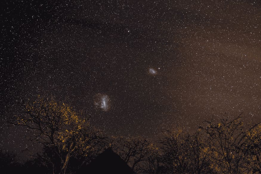 Nuvens de Magalhães visíveis no céu estrelado, exemplos próximos de galáxias anãs satélites da Via Láctea