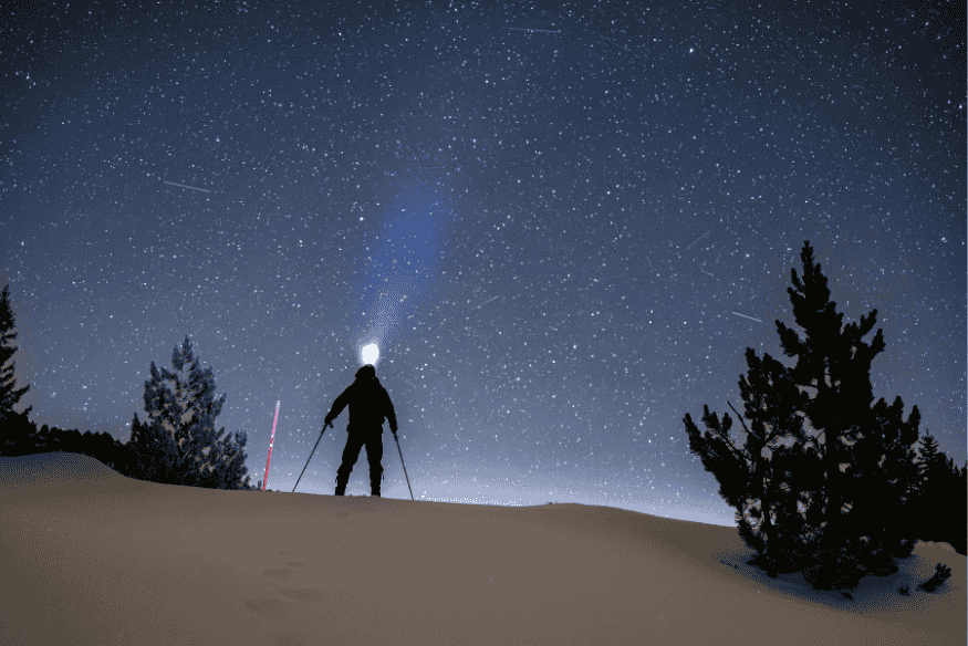Observador sob céu estrelado analisando a luz antiga do universo