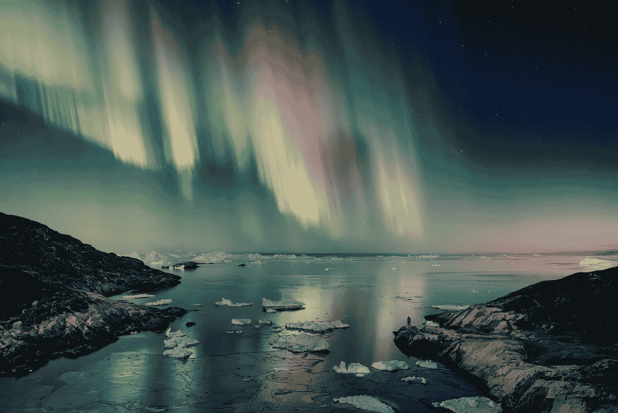 Aurora boreal sobre região gelada durante a noite, exemplo de fenômeno diferente do airglow no céu