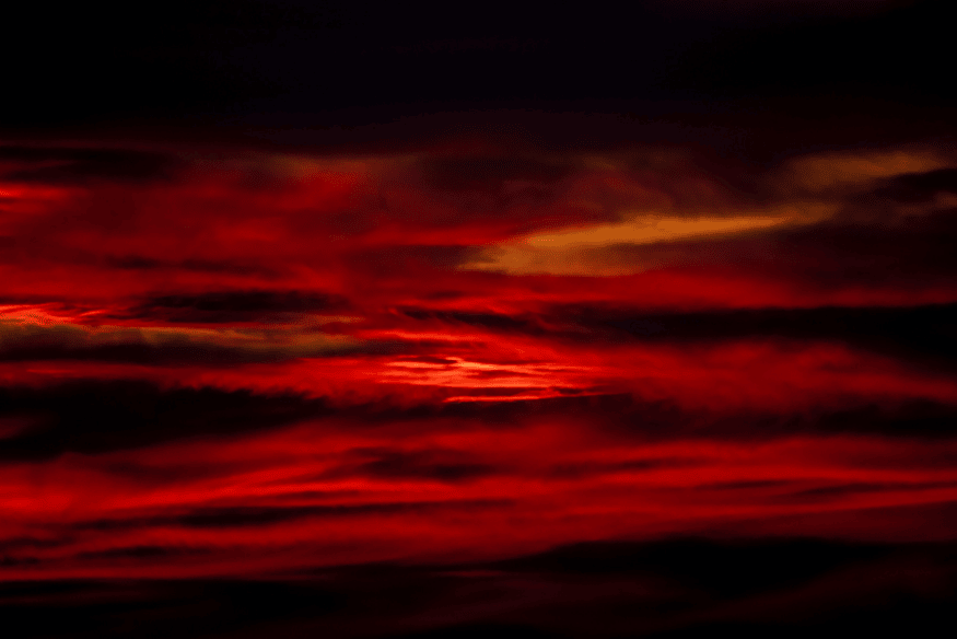 Céu avermelhado com nuvens intensas ao entardecer, efeito visual que pode ser confundido com fenômenos atmosféricos como o airglow