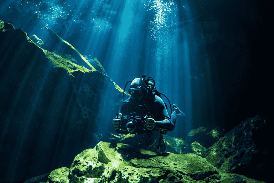 Mergulhador explorando caverna subaquática, analogia para oceanos subterrâneos em luas geladas do Sistema Solar