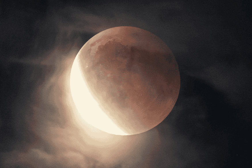 Lua parcialmente iluminada no céu noturno, mostrando a face lunar visível da Terra