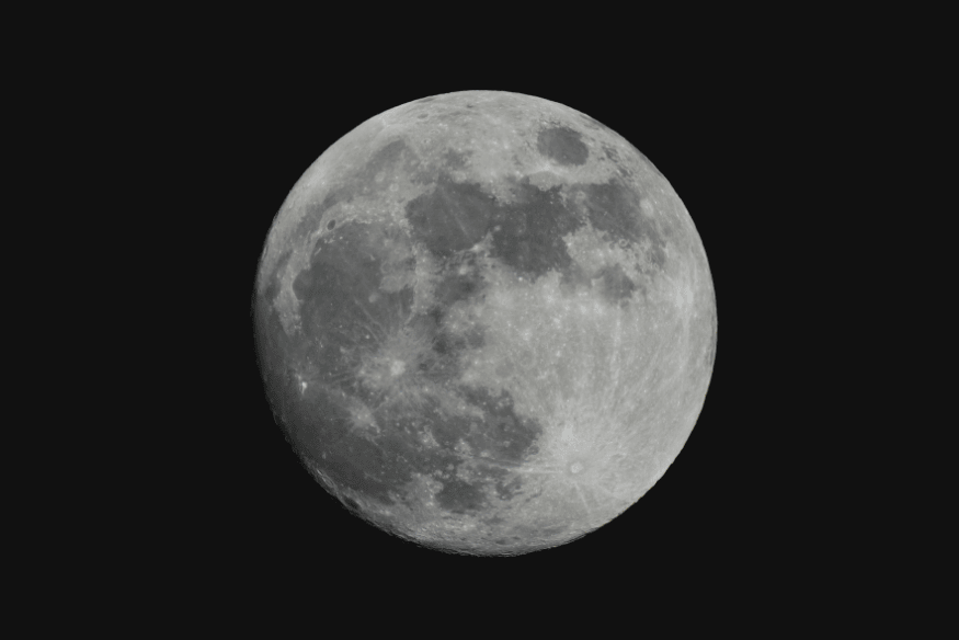 Lua cheia em fundo escuro, destacando mares lunares e crateras visíveis da Terra