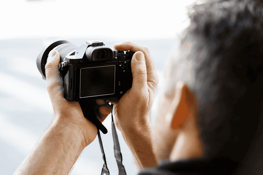 Pessoa segurando câmera fotográfica, representando a configuração do equipamento para escolher entre RAW e JPEG na astrofotografia