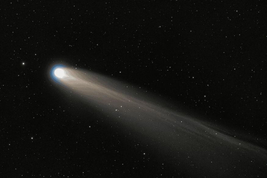 Cometa com núcleo brilhante e longa cauda luminosa no espaço, destacando a presença de gás ionizado empurrado pelo vento solar