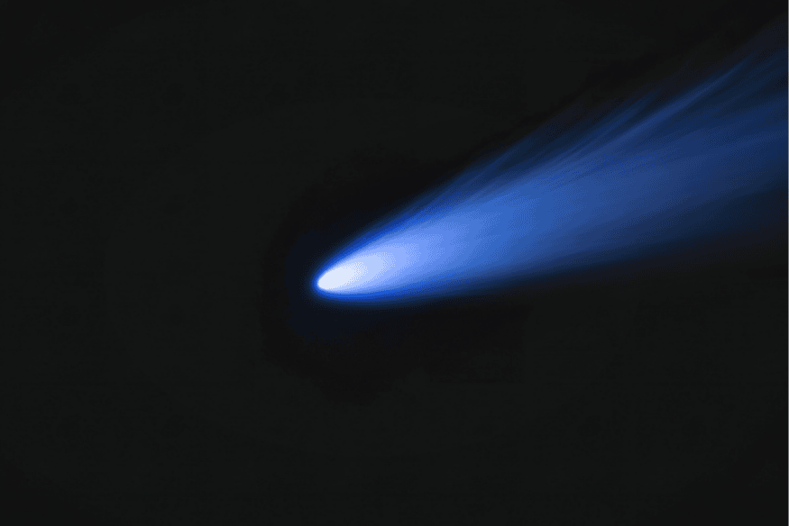 Cometa azul brilhante com cauda luminosa em fundo escuro, exemplo de objeto celeste com estrutura de cauda dupla no espaço