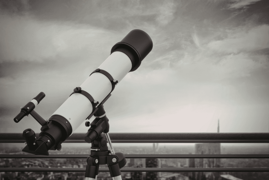Telescópio refrator montado em varanda urbana, exemplo de equipamento inicial em que uma buscadora óptica pode ajudar a localizar objetos no céu