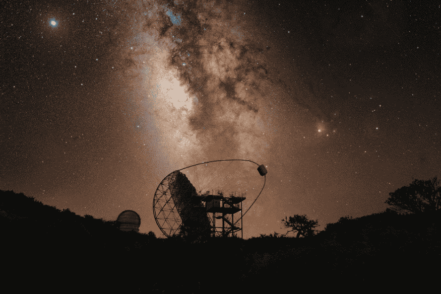 Radiotelescópio observando o céu noturno como ferramenta da astronomia multimensageira