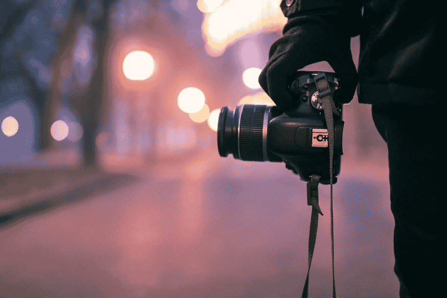 Câmera fotográfica em ambiente urbano ao entardecer, representando a etapa inicial de captura que influencia o resultado final do pós-processamento na astrofotografia